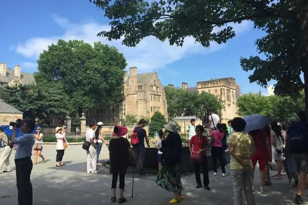 中国游客围在耶鲁大学“女生台”旁参观拍照。
