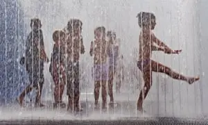 Children play in the fountains outside the Hayward Gallery on the South Bank, London, enjoying the hot, sunny weather. Commissioned
